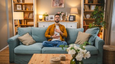 Kafkasyalı erkek, evde meditasyon yoga eğitimi alıyor.