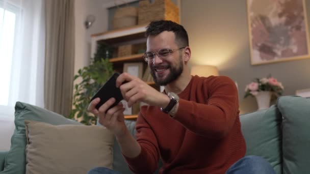 一个成年人在家里玩电玩手机智能手机 — 图库视频影像