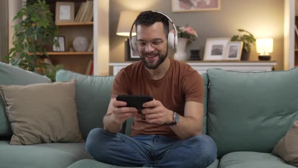 Ένας Ενήλικας Παίζει Βιντεοπαιχνίδια Χρησιμοποιεί Κινητό Τηλέφωνο Smartphone Στο Σπίτι — Αρχείο Βίντεο
