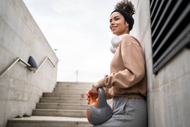 Kafkasyalı genç bir bayan sporcu gün içinde dışarıda Rus çanı Girya Kettlebell ağırlık egzersizi ile antrenman yapıyor.