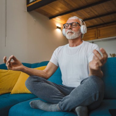 Üst düzey Kafkas erkek gözleri, kulaklıklarla evde otururken yoga ya da meditasyon için kapalı. Gerçek insanların iç huzuru ve denge konsepti.