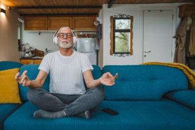 Üst düzey Kafkas erkek gözleri, kulaklıklarla evde otururken yoga ya da meditasyon için kapalı. Gerçek insanların iç huzuru ve denge konsepti.