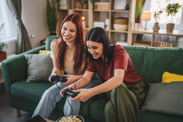 Kafkasyalı iki genç kadın arkadaş veya kız kardeş konsol video oyunu oynuyorlar