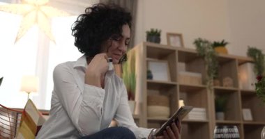 Evde mutlu gülümseyen yetişkin bir kadın banka kredi kartı ve cep telefonu online alışveriş e-bankacılığı konseptini tutuyor. Gerçek insanlar uzay e-ticaretini kopyalayıp rezervasyon yaptırıyor.