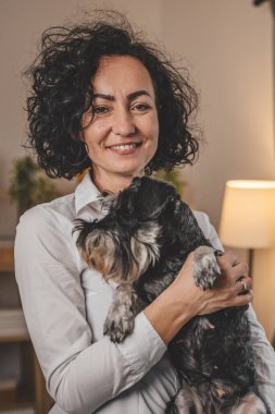 Yetişkin beyaz kadın portresi. Evde evcil köpeği olan olgun bir kadın.