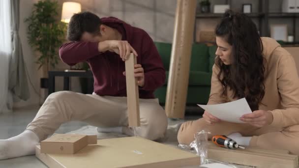 年轻夫妇搬进新公寓时携带组装家具 — 图库视频影像