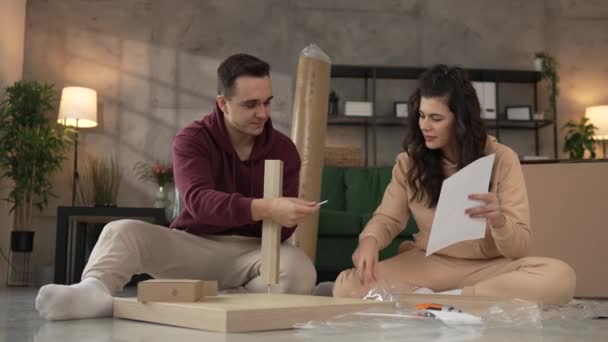 年轻夫妇搬进新公寓时携带组装家具 — 图库视频影像