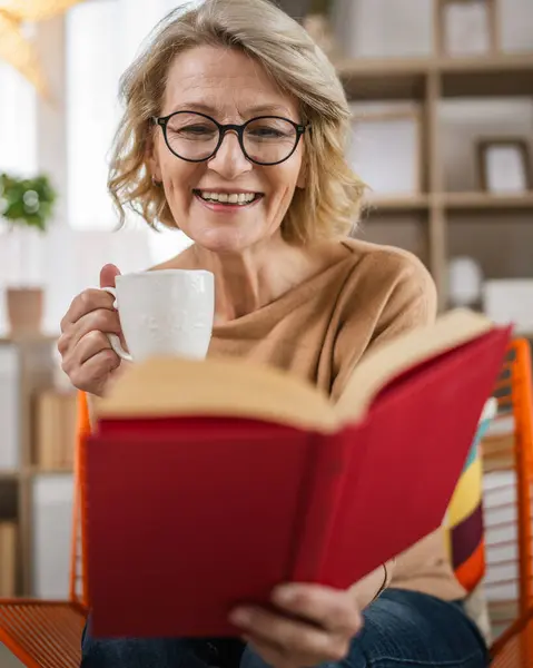 Yetişkin Bir Beyaz Kadın Evde Kitap Okuyor Gözlük Takıyor — Stok fotoğraf