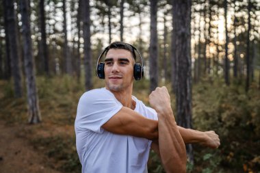 Bir erkek beyaz erkek sporcu ormanda doğada koşuyor ya da sonbaharda ya da yaz günlerinde spor yapıyor spor yapıyor spor yapıyor sağlıklı yaşam tarzı kavramı gerçek insanlar mekanı kopyalıyor.