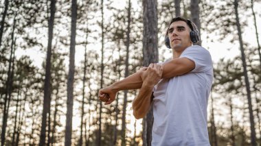 Bir erkek beyaz erkek sporcu ormanda doğada koşuyor ya da sonbaharda ya da yaz günlerinde spor yapıyor spor yapıyor spor yapıyor sağlıklı yaşam tarzı kavramı gerçek insanlar mekanı kopyalıyor.