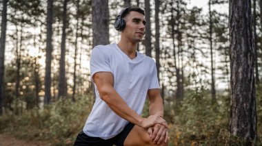 Bir erkek beyaz erkek sporcu ormanda doğada koşuyor ya da sonbaharda ya da yaz günlerinde spor yapıyor spor yapıyor spor yapıyor sağlıklı yaşam tarzı kavramı gerçek insanlar mekanı kopyalıyor.