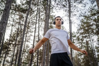 Bir erkek beyaz erkek sporcu ormanda doğada koşuyor ya da sonbaharda ya da yaz günlerinde spor yapıyor spor yapıyor spor yapıyor sağlıklı yaşam tarzı kavramı gerçek insanlar mekanı kopyalıyor.