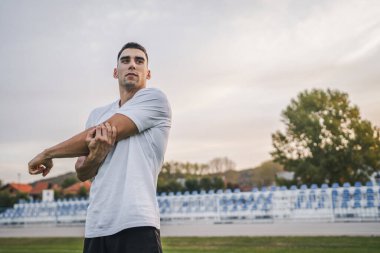 Bir erkek beyaz erkek atlet stadyum pistinde koşuyor ya da sonbahar ya da yaz sporlarında spor yapıyor spor yapıyor spor yapıyor sağlıklı yaşam tarzı kavramını gerçek insanlar taklit ediyor.