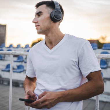 Sabah koşarken cep telefonu kullanan bir sporcunun portresi kulaklıkla müzik dinleyen atletik bir adam cep telefonu uygulaması kullanıyor