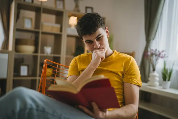 若い男慎重な十代の若者は家庭教育の概念で本の勉強を読む — ストック写真