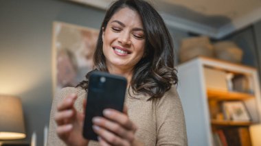 Yetişkin bir beyaz kadın cep telefonuyla mesaj atıyor.