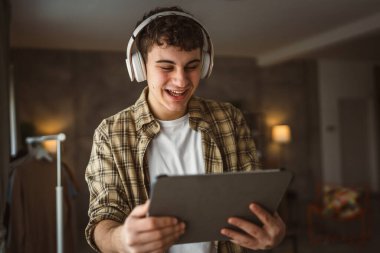 Kafkasyalı bir erkek, internet üzerinden video izleyip dijital tablet kullanıyor.