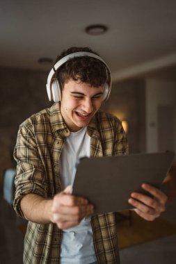 Kafkasyalı bir erkek, internet üzerinden video izleyip dijital tablet kullanıyor.