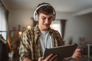 Kafkasyalı bir erkek, internet üzerinden video izleyip dijital tablet kullanıyor.