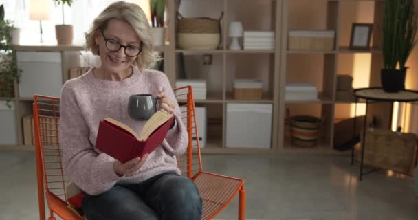 Одна Взрослая Белая Женщина Читает Книгу Дома Очках — стоковое видео