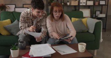 Genç çift, erkek arkadaş, kız arkadaş ya da erkek kardeş evde ders çalışıyor.