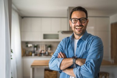 Bir yetişkin portresi, sakallı ve gözlüklü beyaz bir erkek. Mutlu bir gülümseme.