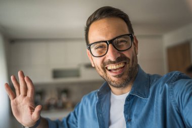Bir yetişkin portresi, sakallı ve gözlüklü beyaz bir erkeğin mutlu bir gülümseme ile kendi portresinin fotokopisini çeker.