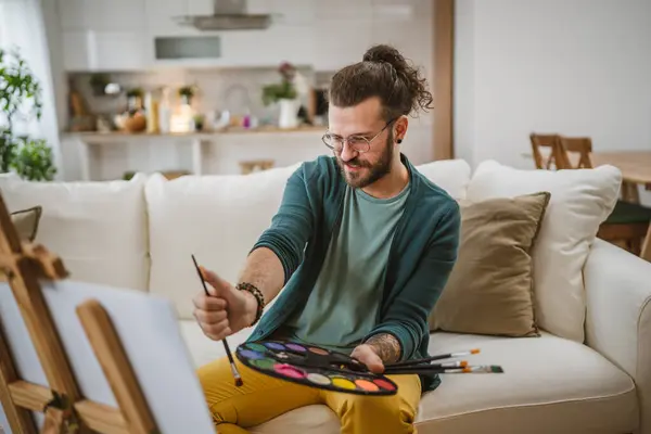 modern man with beard and mustaches paint painting at home hold brush