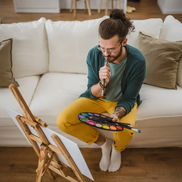 modern man with beard and mustaches paint painting at home hold brush