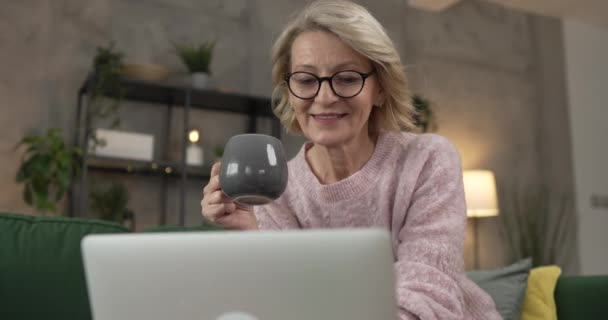 Reife Blonde Kaukasische Frau Nutzt Laptop Hause Für Die Arbeit — Stockvideo