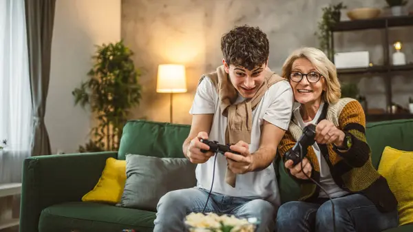少年男子和他的母亲成熟女子男子玩游戏机 — 图库照片
