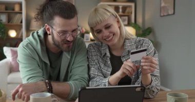Yetişkin mutlu çift, internetten alışveriş yapıyor. Kredi kartı tutuyor.