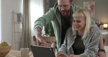 Yetişkin mutlu çift, internetten alışveriş yapıyor. Kredi kartı tutuyor.