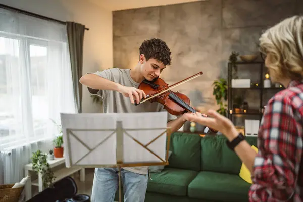 Молодой Человек Учится Играть Скрипке Руководством Зрелой Женщины Преподавателя Дома — стоковое фото