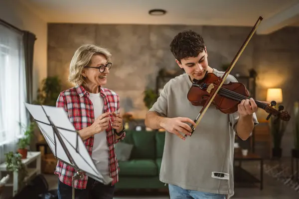Молодой Человек Учится Играть Скрипке Руководством Зрелой Женщины Преподавателя Дома — стоковое фото