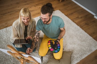 Çiftler resim sehpasında resim yapar. Fırça kullanmayı öğrenmelerine yardımcı olur. Mutlu erkek ve kadın aşık olur.