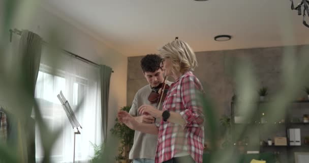 Νεαρός Άνδρας Μάθουν Πώς Παίζουν Βιολί Υπό Την Καθοδήγηση Της — Αρχείο Βίντεο