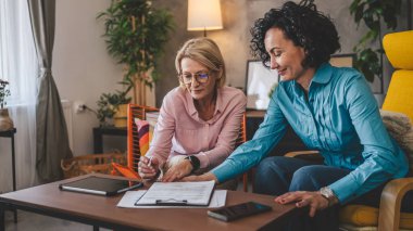 Ev sözleşmesi belgesi veya sigorta poliçesinden iki kadın çalışıyor