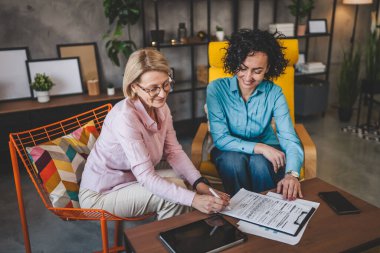 Ev sözleşmesi belgesi veya sigorta poliçesinden iki kadın çalışıyor