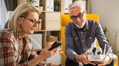 Evde olgun ya da yaşlı bir çift Kafkasyalı karı ve koca birbirlerine bağlanıyor ve güvenlik kamerası kuruyorlar.