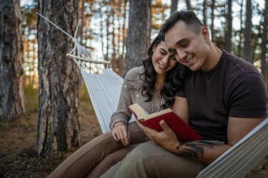 Erkek ve kadın, genç yetişkin bir çift, aşık olup kitap okuyorlar.