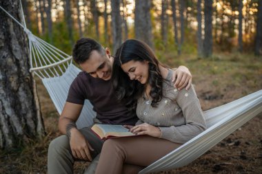 Erkek ve kadın, genç yetişkin bir çift, aşık olup kitap okuyorlar.