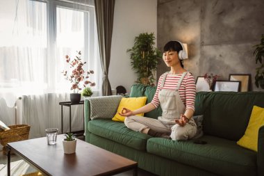 Olgun Japon kadın evde meditasyon egzersizi yapıyor.