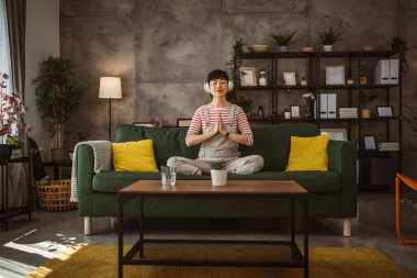 Olgun Japon kadın evde meditasyon egzersizi yapıyor.