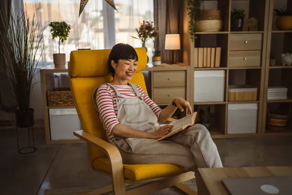1人の女性成熟した日本人女性が自宅で本を読む — ストック写真