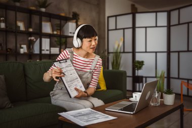 Yetişkin kadın Japon iş kadını video araması yapar ev içi internet danışmanlığı ya da konferans kağıdı belge sözleşmesi ya da istatistikleri gösterir.