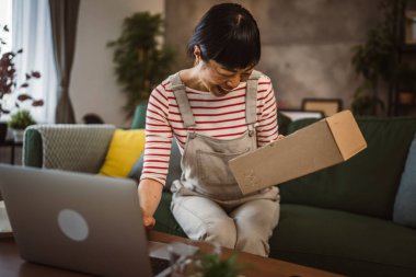 Japon kadın evde paket veya ürün kutusunu işaretliyor