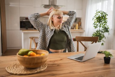 Genç beyaz bir kadın sabah rutini yapar ve evinde mutlu mesut uzanır.