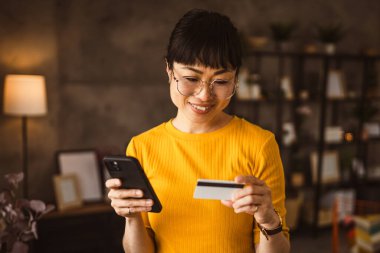 Japon olgun kadın internet üzerinden cep telefonu ve kredi kartıyla satın alıyor.