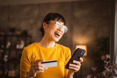 Japon olgun kadın internet üzerinden cep telefonu ve kredi kartıyla satın alıyor.